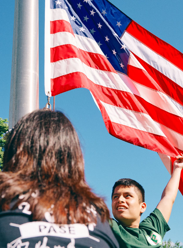 Group of students lifting up USA flag