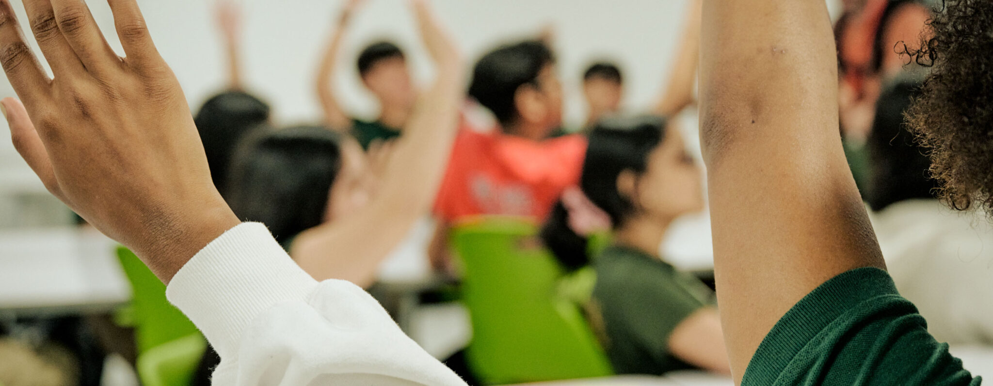 group of students raising hands