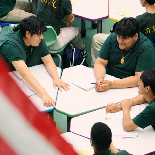 overhead shot of students engaging around table with American flag in foreground corner