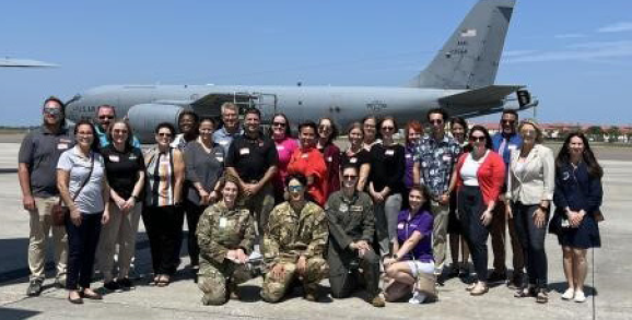 iCivics Civics Service and Leadership professional learning group on air base in front of military aircraft